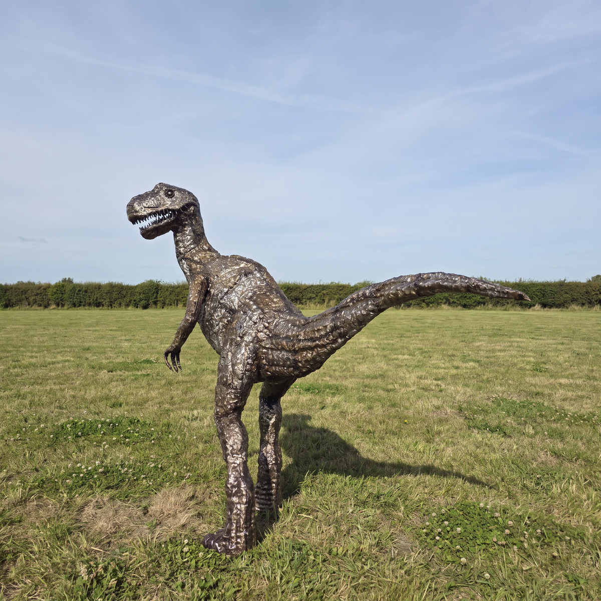 One-of-one metal Raptor sculpture displayed outdoors, rear view