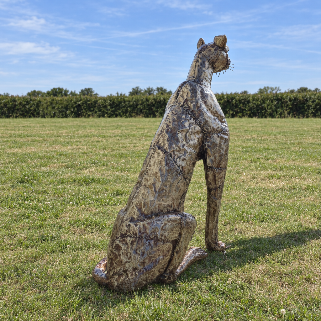 Sitting Cheetah Sculpture - Head Up, rear view in an outdoor setting