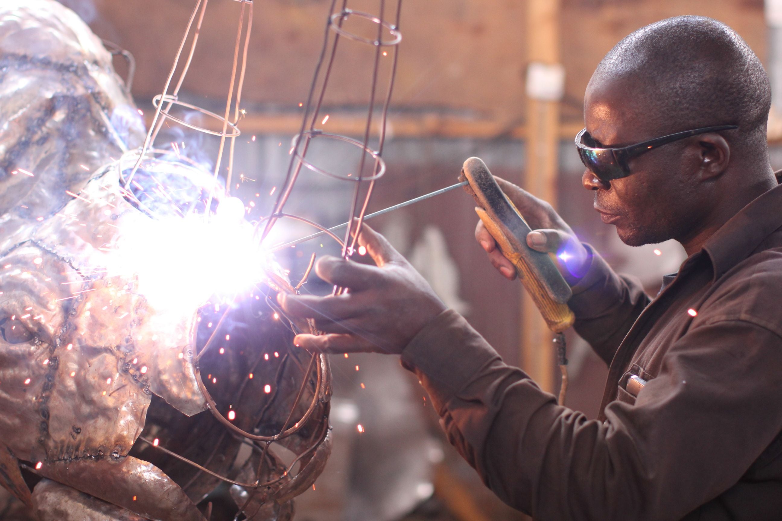 Artisan welding a custom metal sculpture